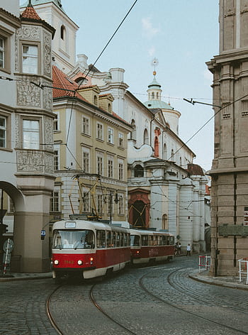 Vintage trams navigating through the historic streets of Prague, a city rich in architectural heritage. HD phone wallpaper