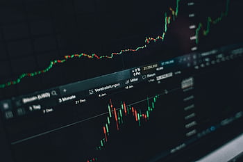 Close-up of a digital market analysis display showing Bitcoin and cryptocurrency price trends. HD wallpaper
