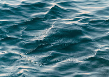 Calm blue ocean waves creating a soothing ripple texture, ideal for backgrounds. HD wallpaper