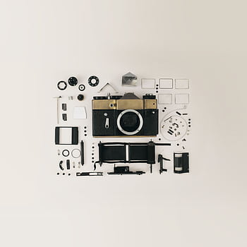 Flat lay of disassembled vintage camera parts showcasing intricate components and design. HD phone wallpaper