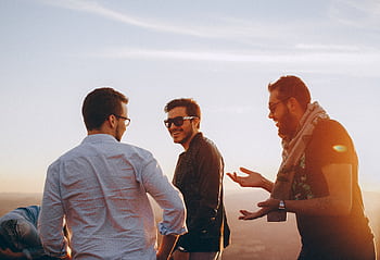 Group of male friends laughing together outdoors during sunset in Brazil. HD wallpaper