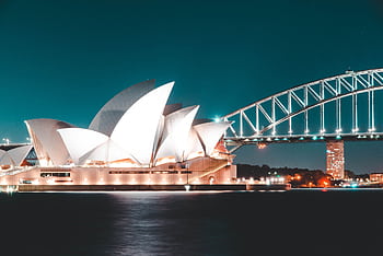 Stunning night view of Sydney Opera House and Harbour Bridge, beautifully illuminated against a clear sky. HD wallpaper