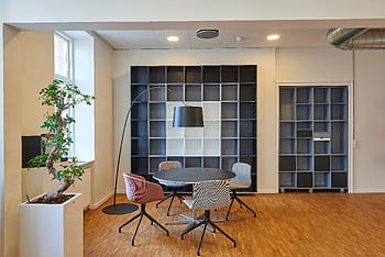 Bright and stylish office space with contemporary furniture and open shelving. HD wallpaper