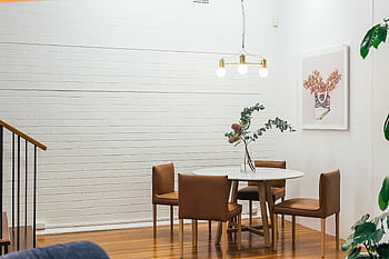 A stylish minimalist dining room with modern decor and wooden furniture. HD wallpaper