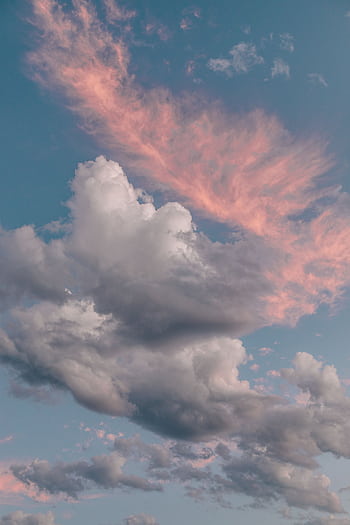 A stunning vertical shot of dramatic clouds with pink hues in the sky, perfect for nature themes. HD phone wallpaper