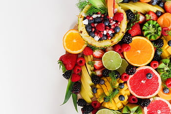 Colorful flat lay of assorted tropical fruits including pineapple, berries, and citrus. HD wallpaper
