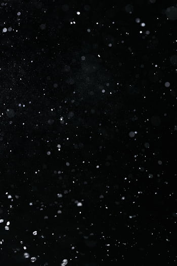 A dramatic high-speed capture of water particles on a black background, ideal for visual effects. HD phone wallpaper