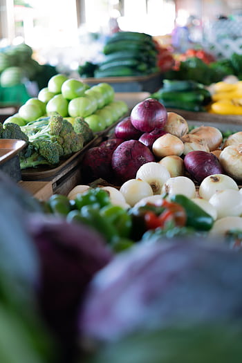 A colorful array of fresh vegetables displayed at an outdoor market. HD phone wallpaper
