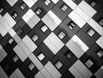 A striking monochrome of a modern building's geometric facade with windows. HD wallpaper