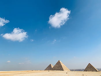 The historic Pyramids of Giza framed by a vast desert and blue sky, perfect for travel and tourism themes. HD wallpaper