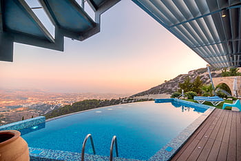 Infinity pool with breathtaking mountain and city views, perfect for a luxury tropical getaway. HD wallpaper