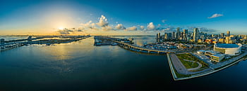Aerial view of the Miami skyline with sunrise reflecting on the ocean. HD wallpaper