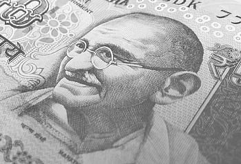 Detailed monochrome depiction of an Indian rupee banknote with Gandhi's portrait, symbolizing finance and economy. HD wallpaper