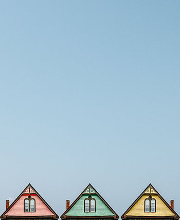 Three colorful triangular rooftops against a clear blue sky, showcasing simple architectural design. HD phone wallpaper