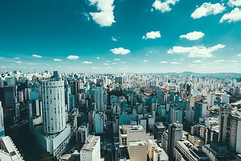 Expansive aerial view of Sao Paulo showcasing skyscrapers and a vibrant urban skyline under a blue sky. HD wallpaper
