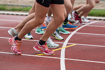 Close-up of athletes' feet at the starting line, prepared for a track race. HD wallpaper