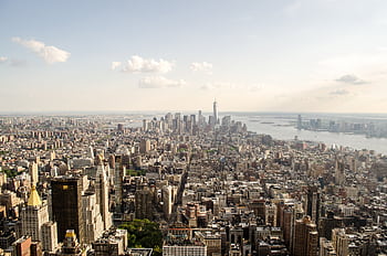 A breathtaking aerial view of New York City showcasing the iconic skyline over the river under a clear sky. HD wallpaper