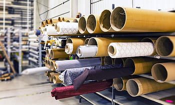 Rows of textile rolls stored in a factory for industrial manufacturing. HD wallpaper