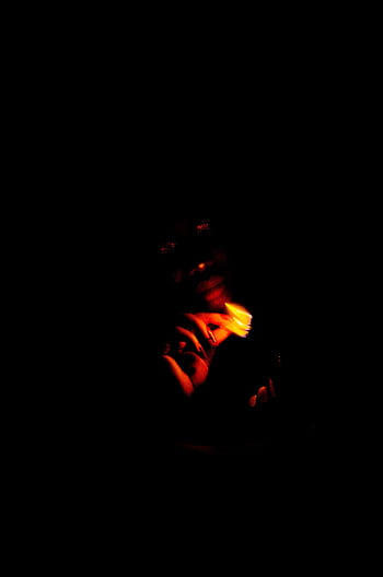 A captivating close-up of a person holding a burning match against a dark background. HD phone wallpaper