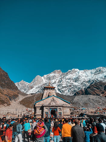 A large gathering of tourists at the Kedarnath Temple in the Himalayas, under a clear blue sky. HD phone wallpaper