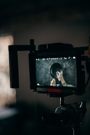 Close-up of a video production setup featuring a monitor displaying hands managing equipment. HD phone wallpaper