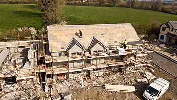 Aerial shot of a house under construction in Clonmel, Ireland. Workers on the roof. HD wallpaper