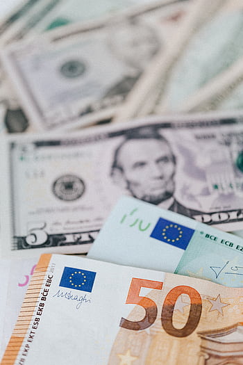 Close-up of various euro and dollar banknotes, symbolizing currency exchange and finance. HD phone wallpaper