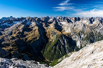 Breathtaking aerial view of rugged Alpine mountains under a clear blue sky. HD wallpaper