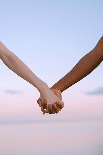 Closeup of multiracial hands holding, symbolizing unity and equality against a serene sky. HD phone wallpaper
