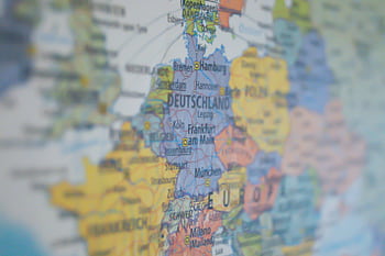 Close-up view of Germany on a colorful world map showing major cities. HD wallpaper