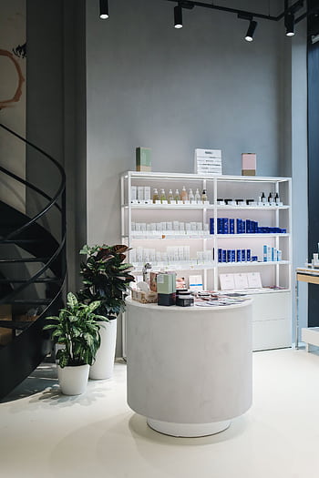 Contemporary beauty store interior showcasing various cosmetics on elegant shelves. HD phone wallpaper