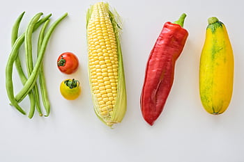 A vibrant assortment of fresh vegetables including corn, peppers, beans, and tomatoes. HD wallpaper