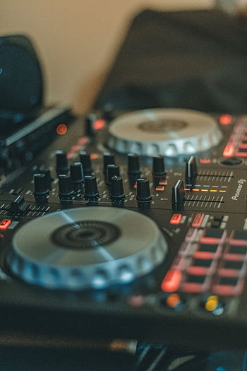 Close-up of a professional DJ mixing console featuring turntables and various controls for music production. HD phone wallpaper