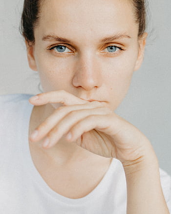 Close-up portrait of a woman with blue eyes, looking thoughtful and serene. HD phone wallpaper
