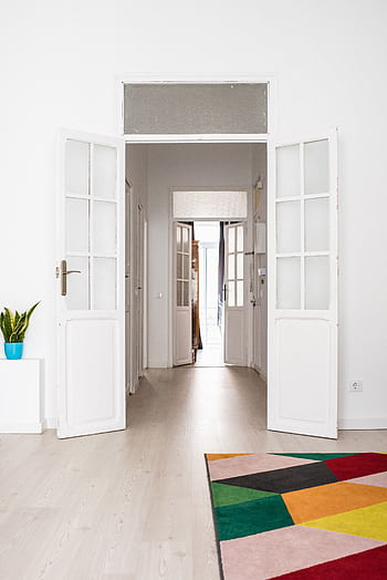 Spacious and colorful modern living room featuring open doors and vibrant decor. HD phone wallpaper