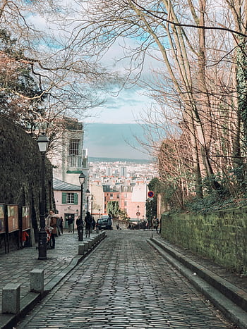 que cobblestone street in Montmartre with city view, capturing Parisian charm. HD phone wallpaper