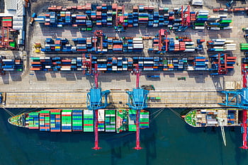Drone shot capturing vibrant container ships and dock in North Jakarta port, Indonesia. HD wallpaper