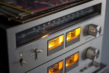 Close-up of retro audio equipment featuring illuminated dials and radio tuner. HD wallpaper