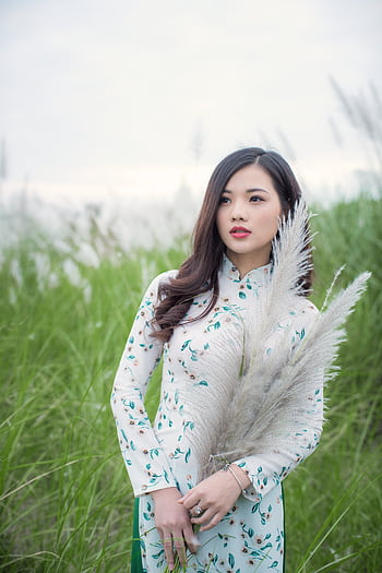 Stylish young woman in floral dress holding pampas grass in an open field. HD phone wallpaper