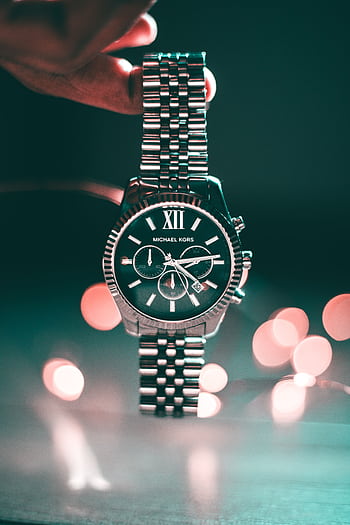 Silver Michael Kors wristwatch with Roman numerals and elegant design, highlighted by bokeh lights. HD phone wallpaper