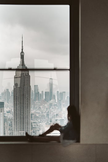 View of the Empire State Building from a window with a silhouette in the foreground. HD phone wallpaper