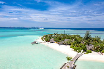 Aerial view of an idyllic tropical island resort with turquoise waters and sandy beaches. HD wallpaper