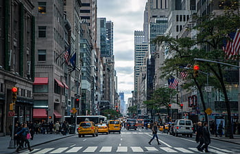 Vibrant street view of New York City with pedestrians, yellow cabs, and skyscrapers. HD wallpaper