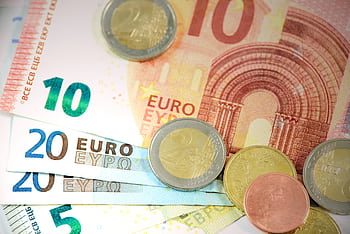 Detailed shot of Euro banknotes and coins showcasing currency denominations. HD wallpaper