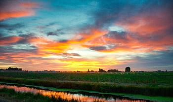 Stunning sunset with vivid colors over a tranquil Idaho farmland, capturing serene rural beauty. HD wallpaper