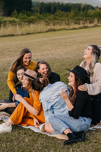 A group of smiling young women enjoying each other's company outdoors on a sunny day. HD phone wallpaper