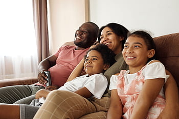 Happy multicultural family enjoying quality time together on a sofa at home. HD wallpaper