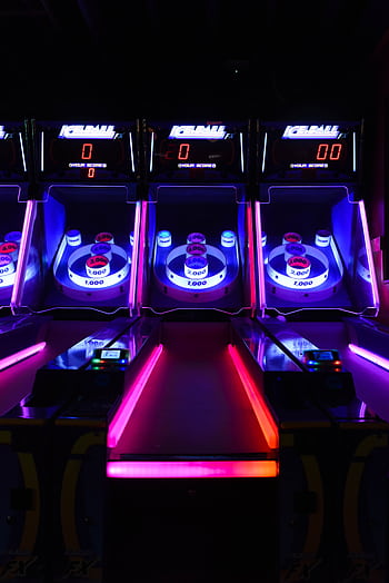 Vibrant and illuminated ski ball machines in a dark arcade setting. HD phone wallpaper