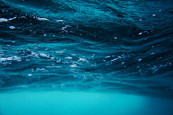 Serene underwater view of sea surface with vibrant turquoise and blue waves. HD wallpaper