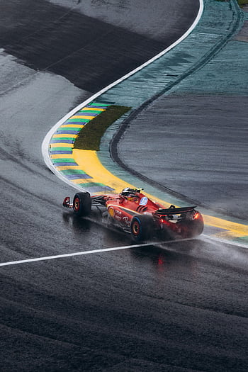 Ferrari Formula 1 car navigating a wet curve at Interlagos race track in Brazil. HD phone wallpaper